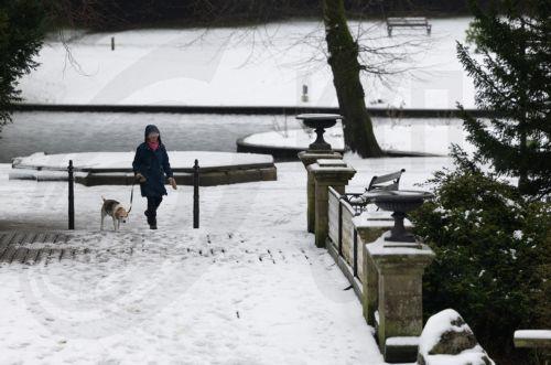 epa12637951 A person walks their dog through snow in the Pavilion Gardens in Buxton, Britain, 09 January 2026. Met Office yellow and amber warnings for ice, snow and wind remain in force across much of Britain after Storm Goretti, the first named storm of the year, brought heavy snowfall and strong winds.  EPA/ADAM VAUGHAN