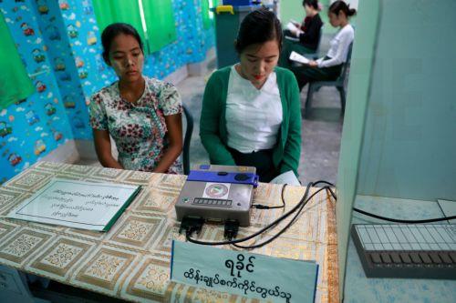 epa12639796 Volunteers of the Union Election Commission (UEC) set up an electronic voting machine at a polling station, one day ahead of the second phase of election in Yangon, Myanmar, 10 January 2026.  Myanmar's military government, known as the State Administration Council (SAC), plans to hold its first national vote since the February 2021 coup in a...