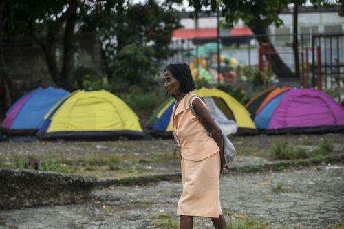 epa12649921 A woman walks past tents set up by relatives of political prisoners in front of the Rodeo I prison in Zamora, Miranda state, Venezuela, 14 January 2026. Venezuela's interim president Delcy Rodriguez stated that 406 political prisoners have been released since December, while NGOs dispute the claim and say the process is marked by delays. ...