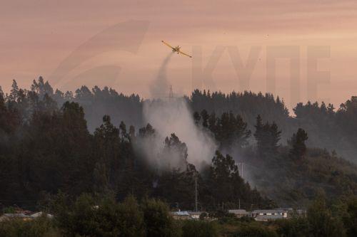 epaselect epa12660281 An airplane conducts water bombing on a forest fire in Penco, Chile, 18 January 2026. Chilean President Gabriel Boric announced on 18 January 2026 that the death toll from the wildfires in the southern regions of Nuble and Biobio had risen to 18.  EPA/PABLO HIDALGO