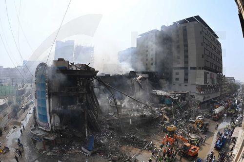 epa12661412 Smoke rises from Gul Plaza following the massive fire in Karachi, Pakistan, 19 January 2026. A deadly fire at Karachi’s Gul Plaza raged for over 24 hours, killing 21 people, including a firefighter, leaving many more missing, and destroying around 1,200 shops. Massive losses were reported as rescue efforts continued amid structural collapse...