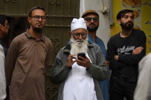 epa12661413 Relatives wait for news as rescue operations continue at Gul Plaza in Karachi, Pakistan, 19 January 2026. A deadly fire at Karachi’s Gul Plaza raged for over 24 hours, killing 21 people, including a firefighter, leaving many more missing, and destroying around 1,200 shops. Massive losses were reported as rescue efforts continued amid structural...