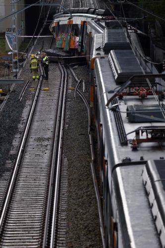 epa12666722 Firefighters check the commuter train that derailed between Gelida and Sant Sadurni d'Anoia, Barcelona, Spain, 21 January 2026. The train driver has died and 37 passengers were injured, four of them seriously, after the train crashed into a collapsed retaining wall late 20 January.  EPA/QUIQUE GARCIA