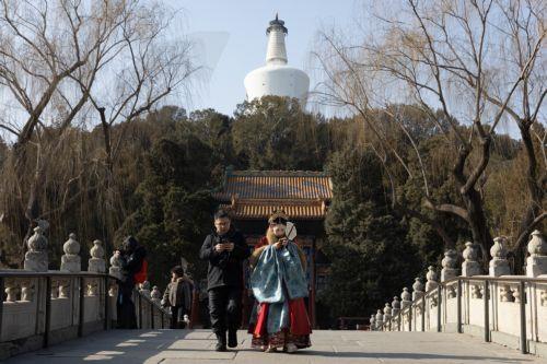 epa12681814 A person dressed in traditional clothing walks near the White Pagoda at a park in Beijing, China, 26 January 2026. In Beijing, tourists can purchase services such as traditional clothing rental, make-up application, hair up-dos, and photography to enhance their cultural experience of the city.  EPA/JESSICA LEE