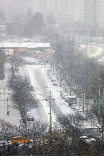 epa12699134 Snow falls on a road in the southeastern city of Daegu, South Korea, 02 February 2026, as weather authorities forecast up to 3 centimeters of snowfall for the region the same day.  EPA/YONHAP SOUTH KOREA OUT