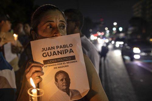 epa12699523 A person holds a candle and a sign during a vigil for the freedom of political prisoners in Plaza de la Republica, Maracaibo, Venezuela, 01 February 2026.  EPA/Henry Chirinos