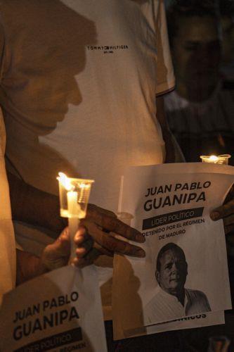 epa12699526 People hold candles and signs during a vigil for the freedom of political prisoners in Plaza de la Republica, Maracaibo, Venezuela, 01 February 2026.  EPA/Henry Chirinos