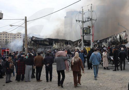 epa12701676 Smoke rises from a fire as people gather around Jannat shopping market in western Tehran, Iran, 03 February 2026. The cause of the fire is unclear.  EPA/ABEDIN TAHERKENAREH