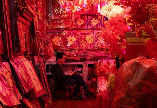 epa12719307 An employee waits for customers beside decorations on sale amid preparations for the Chinese New Year in Beijing, China, 09 February 2026. The Chinese New Year, or Spring Festival, begins on 17 February, ushering in the Year of the Fire Horse with festivities running until the Lantern Festival on 03 March.  EPA/JESSICA LEE