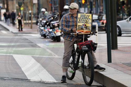 epa12732997 A supporter on the march route displays a small placard as San Francisco teachers and supporters rally as the teachers' strike enters its fourth day in San Francisco, California, USA, 12 February 2026.  The San Francisco Unified School District (SFUSD) and union representatives continue negotiating a new contract as schools remain closed. The...