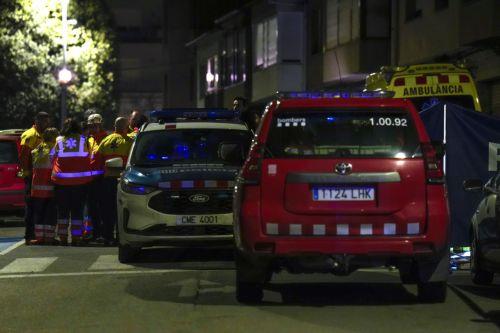 epa12748832 Paramedics (L) stand outside the building where a fire broke out in the town of Manlleu, Barcelona, northeastern Spain, late 16 February 2026 (issued 17 February 2026). At least five teenagers died and four other people were injured in the fire which started in a storage room located on the roof of the building.  EPA/SIU WU