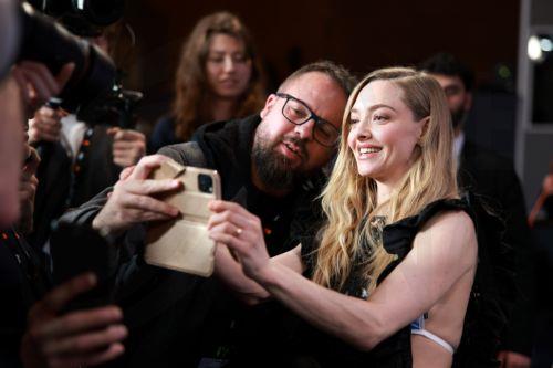 epa12757943 US actor Amanda Seyfried (R) takes a selfie with a fan and member of the media at the end of a press conference for 'The Testament of Ann Lee' during the 76th Berlin International Film Festival, in Berlin, Germany, 19 February 2026. The 76th Berlinale runs from 12 to 22 February 2026.  EPA/CLEMENS BILAN