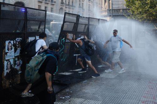 epa12760163 Protesters take cover during clashes with police at a demonstration against labor reform proposed by Argentine President Javier Milei in Buenos Aires, Argentina, 19 February 2026.  EPA/JUAN IGNACIO RONCORONI