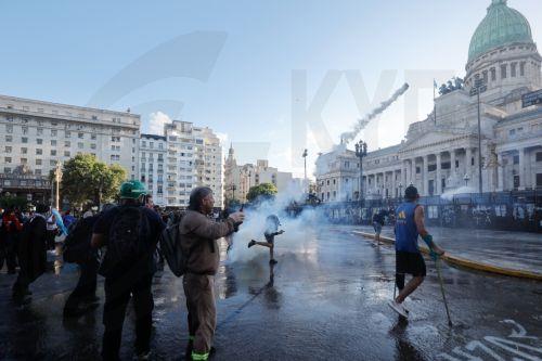epaselect epa12760165 A protester throws a tear gas canister during clashes with police at a demonstration against labor reform proposed by Argentine President Javier Milei in Buenos Aires, Argentina, 19 February 2026.  EPA/JUAN IGNACIO RONCORONI