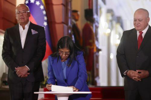 epa12760443 The acting president of Venezuela, Delcy Rodriguez (C), signs the document of the approved amnesty law alongside the president of the National Assembly, Jorge Rodriguez (L), and the Minister of Interior Relations, Justice, and Peace, Diosdado Cabello, in Caracas, Venezuela, 19 February 2026. Rodriguez asked Parliament, the program that promotes...