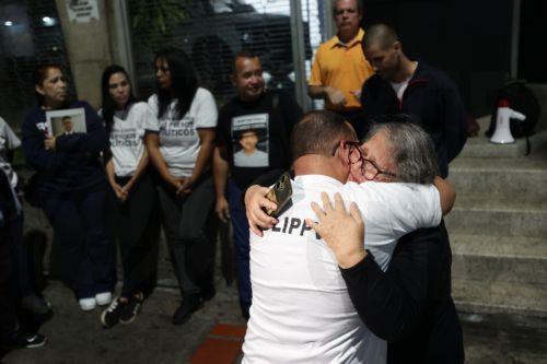 epa12770604 Lewis Jose Mendoza (2-R), the political leader of Vente Venezuela, embraces his mother upon release from the Bolivarian National Police headquarters in La Yaguara, Caracas, Venezuela, 22 February 2026.  EPA/Ronald Pena R
