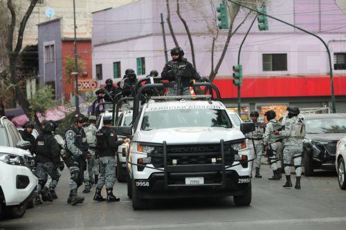 epa12770613 Members of the National Guard guard the area where the body of Nemesio Ruben Oseguera Cervantes, known as El Mencho, leader of the Jalisco New Generation Cartel, is taken after he is killed in Mexico City, Mexico, 22 February 2026. Mexico faces an escalation of violence, with fires and roadblocks reported in at least 16 of its 32 states,...