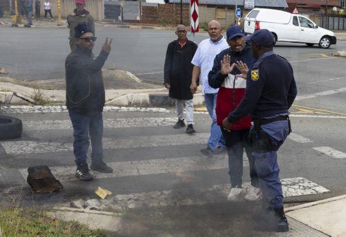 epa12772833 Police officers remove roadblocks from a blockaded street as residents from Coronationville and Westbury protest against the lack of water supply in many parts of Johannesburg, South Africa, 24 February 2026. The city is facing an increasingly dire water situation, with many areas already experiencing 'Zero Day' as their taps run dry. A...