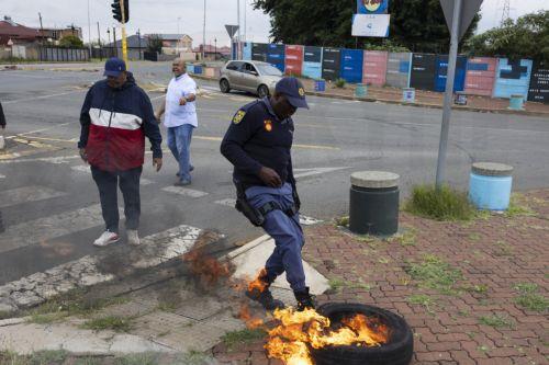 epa12772832 Police officers remove roadblocks from a blockaded street as residents from Coronationville and Westbury protest against the lack of water supply in many parts of Johannesburg, South Africa, 24 February 2026. The city is facing an increasingly dire water situation, with many areas already experiencing 'Zero Day' as their taps run dry. A...