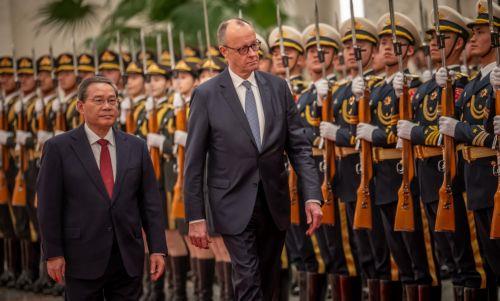 epa12775435 Chancellor of Germany Friedrich Merz (C) is welcomed with military honors at the Great Hall of the People by Li Qiang (L), Premier of China, in Beijing, China, 25 February 2026. Merz is visiting China for the first time as Chancellor.  EPA/Michael Kappeler / POOL