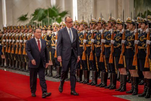 epa12775436 Chancellor of Germany Friedrich Merz (C) is welcomed with military honors at the Great Hall of the People by Li Qiang (L), Premier of China, in Beijing, China, 25 February 2026. Merz is visiting China for the first time as Chancellor.  EPA/Michael Kappeler / POOL