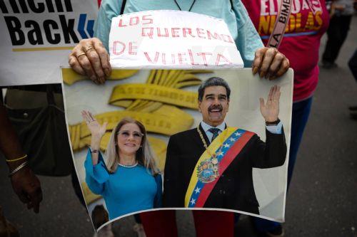 epa12793157 A person holds a sign with the image of Nicolas Maduro and his wife, Cilia Flores, during a march in Caracas, Venezuela, 03 March 2026. Hundreds of Chavistas march to demand the release of Nicolas Maduro and his wife Cilia Flores two months after their capture by US military forces following an attack on Caracas and three nearby regions. ...
