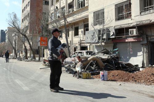 epa12793854 An Iranian man holds his dog as he walks past a damaged building in central Tehran, Iran, 04 March 2026. A joint Israeli and US military operation continues to target multiple locations across Iran since the early hours of 28 February 2026.  EPA/ABEDIN TAHERKENAREH