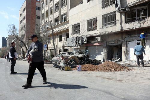 epa12793850 An Iranian man walking with his dog passes a damaged building in central Tehran, Iran, 04 March 2026. A joint Israeli and US military operation continues to target multiple locations across Iran since the early hours of 28 February 2026.  EPA/ABEDIN TAHERKENAREH