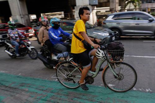 epa12808244 A person on a bicycle travels along a main thoroughfare in Quezon City, Metro Manila, Philippines, 10 March 2026. As significant fuel price hikes hit the Philippines 10 March amidst ongoing Middle East tensions from conflict involving the United States, Israel and Iran, bicycles are expected to be used as alternative modes of transport by...