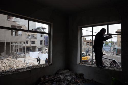 epa12821306 An Iranian man inspects a damaged residential building in southern Tehran, Iran, 15 March 2026. A joint Israeli and US military operation continues to target multiple locations across Iran since the early hours of 28 February 2026.  EPA/ABEDIN TAHERKENAREH