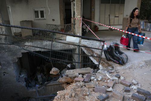 epa12821429 A woman collects her belongings at the scene after fragments from an intercepted Iranian ballistic missile hit in Ramat Gan, Israel, 15 March 2026. The Israeli military said that it detected missiles launched from Iran following earlier US and Israeli strikes.  EPA/ABIR SULTAN