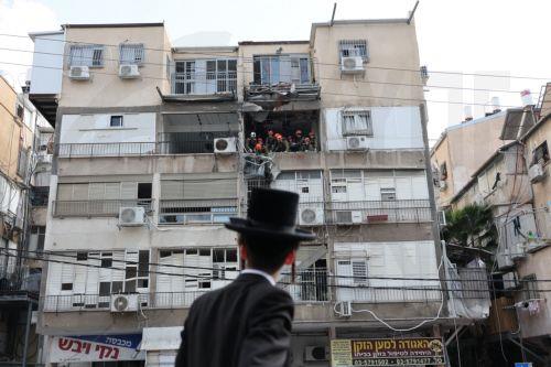 epaselect epa12821231 An Ultra Orthodox Jewish man looks on as Israeli Home Front Command personnel work at the scene after fragments from an intercepted Iranian ballistic missile hit in Bnei Brak, Israel, 15 March 2026. The Israeli military said that it detected missiles launched from Iran following earlier US and Israeli strikes.  EPA/ABIR SULTAN