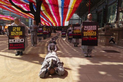 epa12826569 South Korean monks perform the Buddhist praying act of Dharna - walking three steps and making one bow - toward the US Embassy during a protest against US President Trump, in Seoul, South Korea, 17 March 2026. Protesters gathered to oppose Trump’s request for South Korea to send ships to the Strait of Hormuz.  EPA/JEON HEON-KYUN